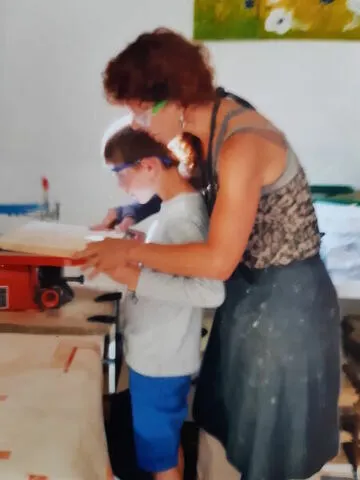 Vrouw en kind snijden hout met figuurzaagmachine - Artsbrico