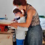 Vrouw en kind snijden hout met figuurzaagmachine - Artsbrico